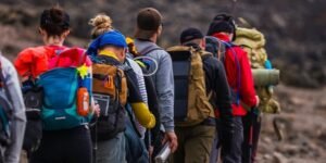 Group of climbers ascending Mount Kilimanjaro’s rocky trail with trekking poles