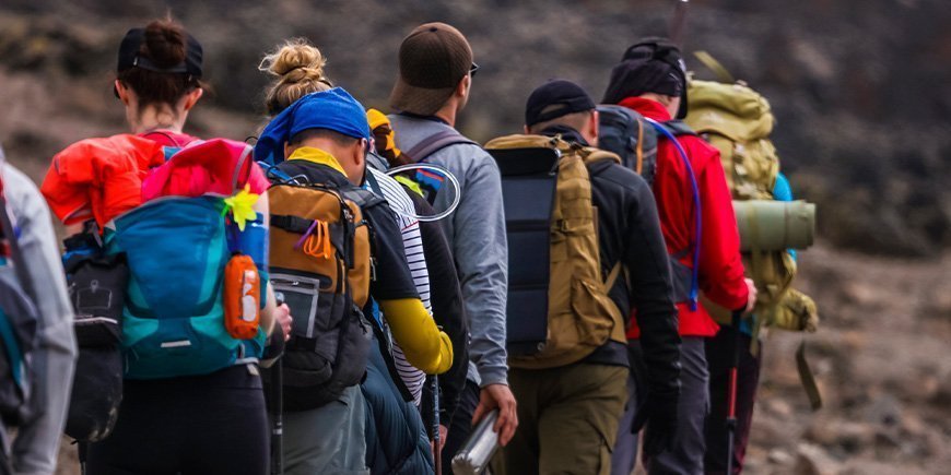 Group of climbers ascending Mount Kilimanjaro’s rocky trail with trekking poles